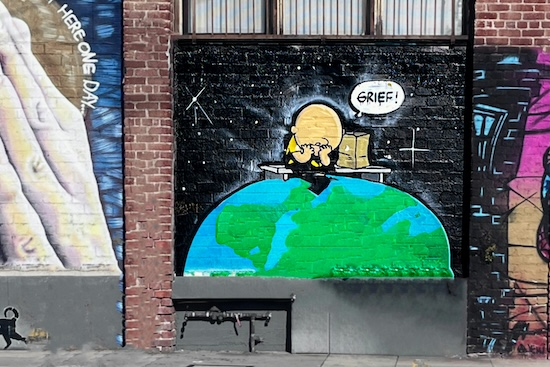 Charlie Brown with his head in his hands looking down at Earth