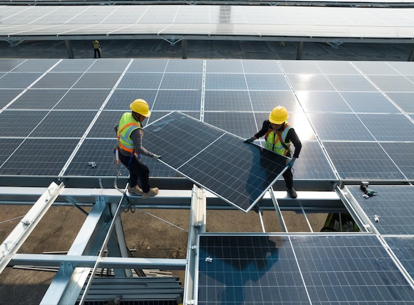 Two men installing solar panels